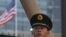 CHINA -- A paramilitary policeman looks on past the U.S. flag on the embassy compounds in Beijing on July 26, 2018 following a blast near the US embassy premises.