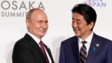 Osaka, Japan - Russia's President Vladimir Putin and Japan's Prime Minister Shinzo Abe / Russia's President Vladimir Putin is greeted by Japan's Prime Minister Shinzo Abe at the G20 leaders summit in Osaka, Japan, June 28, 2019. REUTERS/Kevin Lamarque