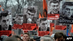 Участники марша несут плакаты с изображением Бориса Немцова