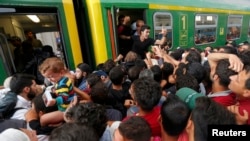 Мигранты штурмуют поезда на вокзале в Будапеште