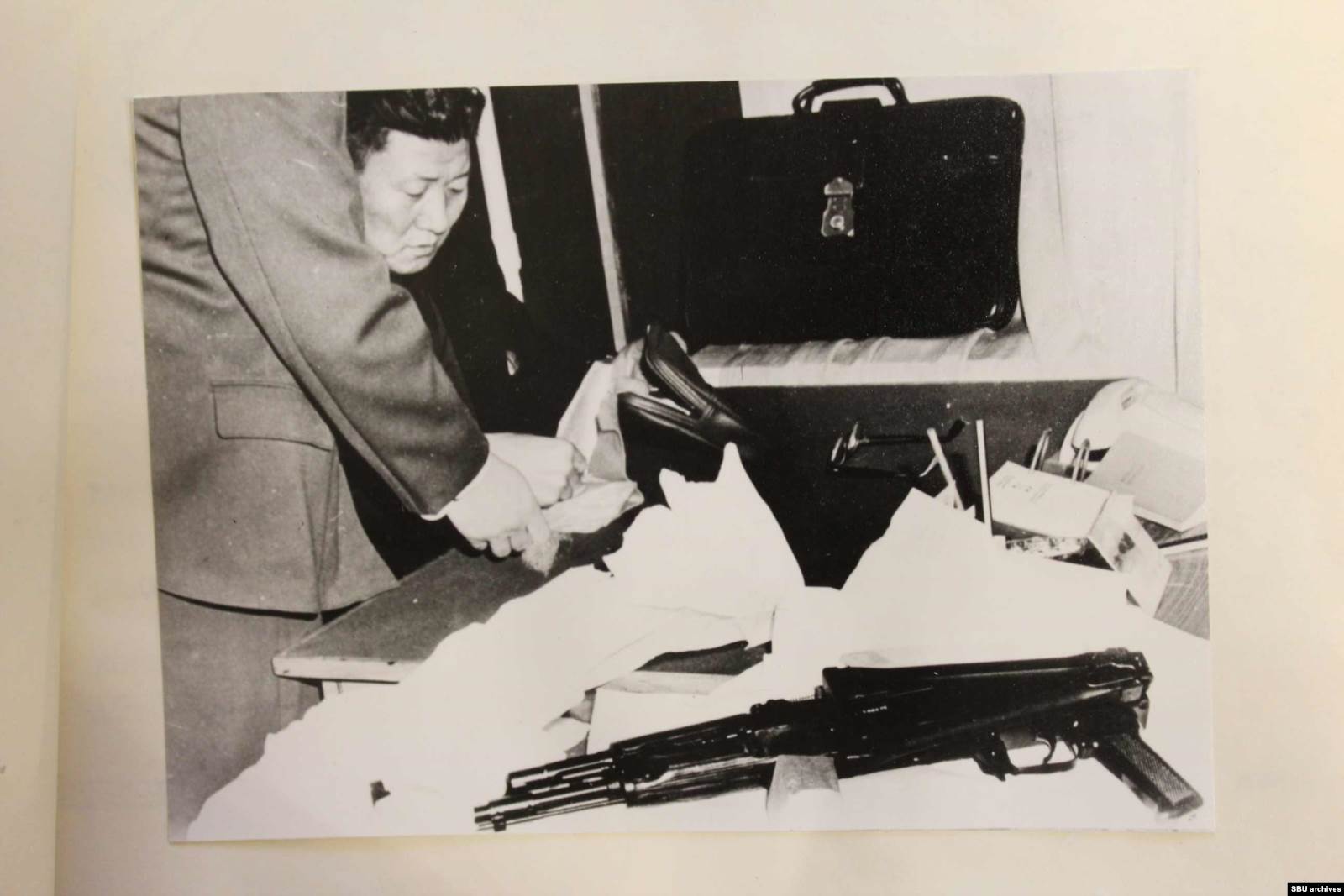  Снимки Хен Кым Сера после задержания. На фото: изъятый автомат и удостоверение помощника военного атташе посольства КНДР