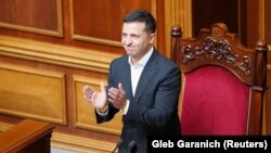 Ukrainian President Volodymyr Zelenskiy applauds during the first session of Ukraine's newly-elected parliament in Kyiv on August 29.