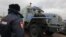 Russia -- A policeman stands in front of a van believed to hold some of the 30 people arrested over a protest at the Prirazlomnaya oil rig as they are transported after arriving at the Ladogsky railway station in St. Petersburg, November 12, 2013