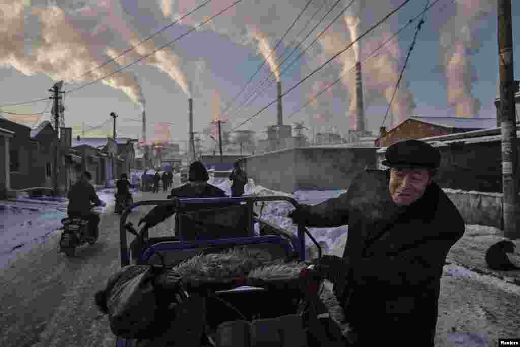 Первая премия в номинации &quot;Повседневная жизнь&quot; досталось Кевину Фрайеру (Kevin Frayer). Китайские мужчины возле угольной электростанции в Шаньси, 26 ноября 2015. На долю Китая, где активно применяется угольное топливо, приходится до трети общемирового объема выбросов углекислого газа