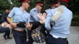 Kazakhstan - Police officers detain a woman during an opposition rally held by critics of Kazakh President Kassym-Jomart Tokayev, who protest over his election in Almaty, Kazakhstan June 12, 2019. REUTERS/Pavel Mikheyev