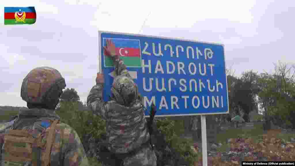 In this photo from the Azerbaijani Defense Ministry, Azerbaijani soldiers place an Azerbaijani flag on a sign for a road leading to the Karabakhi towns of Hadrut and Martuni (Khojavend). The photo was taken in Azerbaijan&#39;s southwestern Jabrayil region, one of seven territories surrounding Nagorno-Karabakh that have been occupied by Armenian forces since the two countries&#39; 1992-1994 war.&nbsp;&nbsp;