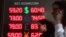 Russia -- People walk past a screen displaying foreign currency exchange rates outside a currency exchange office in Moscow, April 9, 2018