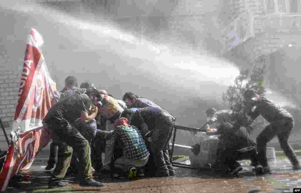 Для подавления протестов полиция применила к людям слезоточивый газ, водометы и резиновые пули На фото - протестанты защищают себя от водомета во время протеста 26 июля