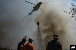 Тушение пожара с помощью вертолета в районе деревни Сирткой неподалеку от Манавгата. 1 августа 2021 года. Фото: AP