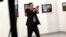 TURKEY -- Mevlut Mert Altintas, an off-duty policeman, shouts after shooting Andrei Karlov, right, the Russian ambassador to Turkey, at an art gallery in Ankara, December 19, 2016