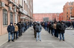Трудовые мигранты в очереди на продление разрешения на проживание в России возле миграционного центра в Санкт-Петербурге. Апрель 2020 года. Фото: EPA