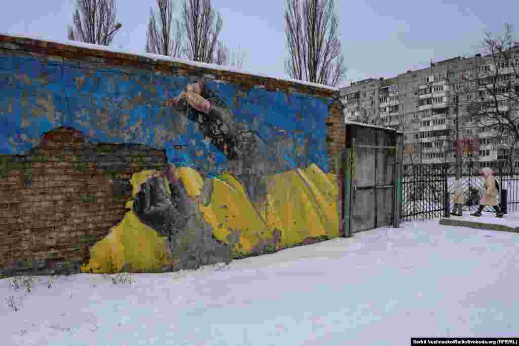 Мурал художника Саши Корбана: руки солдата, сшивающего разорванный украинский флаг. Эту работу Корбан создавал в конце марта 2022 года, когда боевые действия шли рядом с Киевом – в Буче и Ирпене