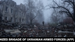 Украинский солдат идет рядом с разрушенными зданиями в прифронтовом городе Константиновка 28 ноября