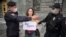 RUSSIA -- Police officers detain a journalist who holds a placard which reads "You are afraid of the truth" during a single picquet of solidarity with collegues who were added to the list of "foreign agent" media near the headquarters of Russia's Federal 