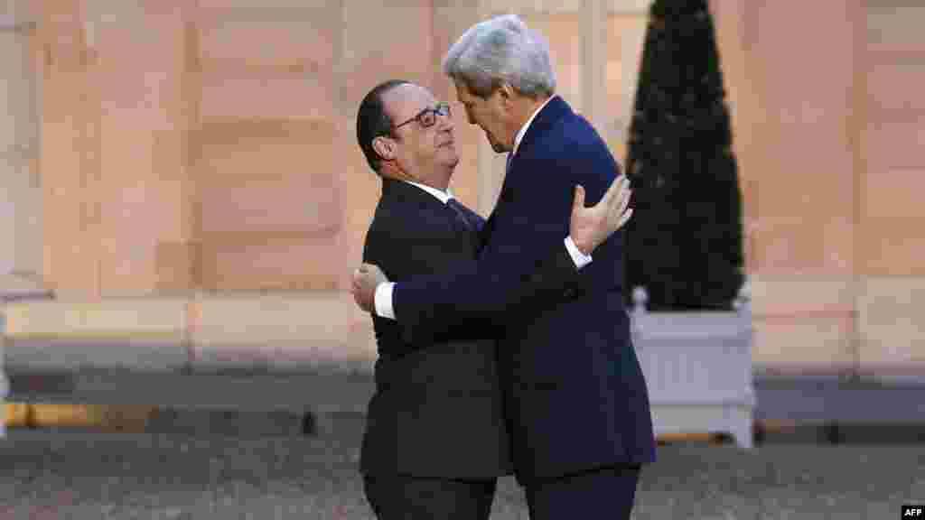 Президент Франции Франсуа Олланд обнимает госсекретаря США Джона Керри во время рабочей встречи на Елисейских полях