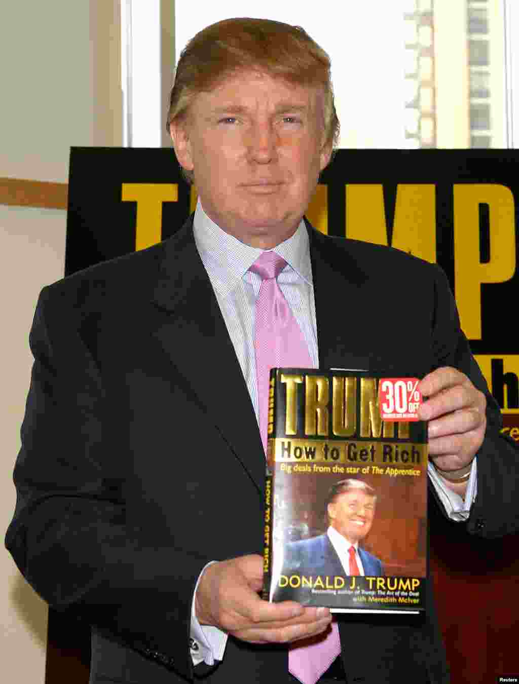 Трамп держит в руках копию своей книги &quot;Как стать богатым&quot;, 2004 год. Его книга &quot;Искусство сделки&quot;, написанная в 1987 году, также бестселлером и приумножила его славу