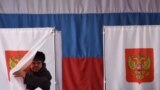 RUSSIA -- A woman walks out of a voting booth at a polling station during Russia's presidential election in the village of Novye Bateki, some 15 km north of Smolensk, on March 18, 2018.