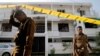 Police keep watch outside the family home of a bomber suspect, Sri Lanka