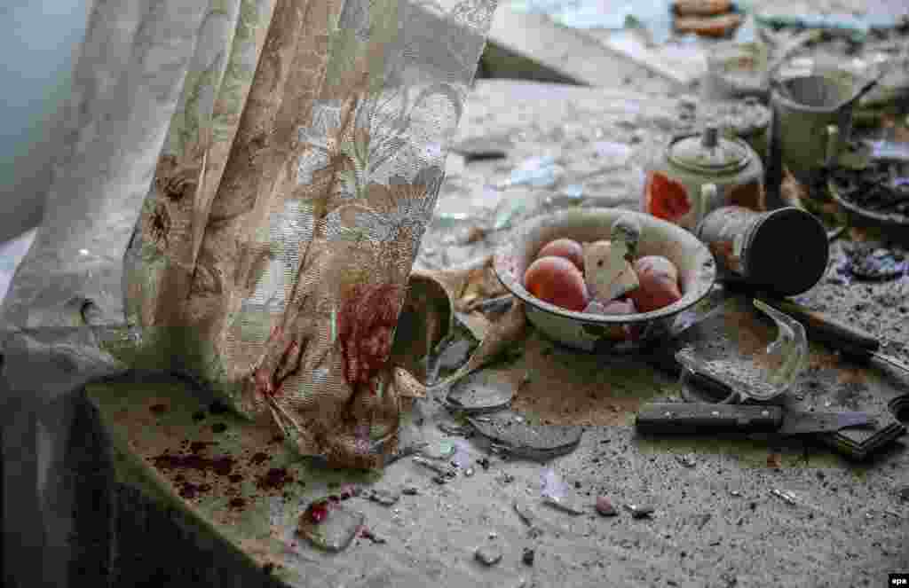 Пыль, стекло и поврежденные предметы домашнего обихода на кухне в одном из домов в Донецке, Украина. 26 августа. (Sergei Ilnitsky, epa)