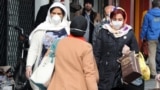 Iranian women wearing face mask walk past in a street of Tehran, Iran, 26 February 2020.
