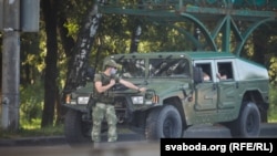 Armored military vehicles carrying armed men in camouflage were seen in Minsk toward the close of voting on August 9, 2020. 
