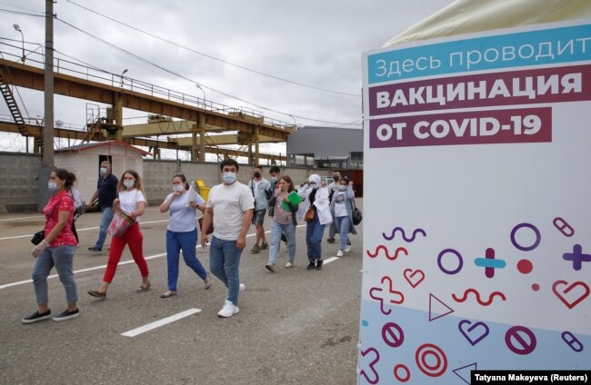 Трудовые мигранты идут в центр вакцинации от COVID-19 на городском рынке в Москве. 30 июня 2021 года. Фото: Reuters