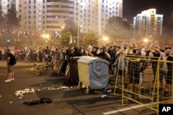 Protesters in Minsk try to set up a barricade with dumpsters during clashes with police after the Belarusian presidential election on August 9, 2020.