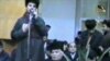 Uzbekistan - IMU former leader Tohir Yuldash speaking after seizing government building in Namangan, with president Islam Karimov kneeling as thousands of Tahir Yuladash's followers crowd the building. Photo taken from amateur video.