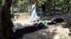 AFGHANISTAN -- Afghan men try to identify the dead bodies at a hospital in Kabul, August 27, 2021