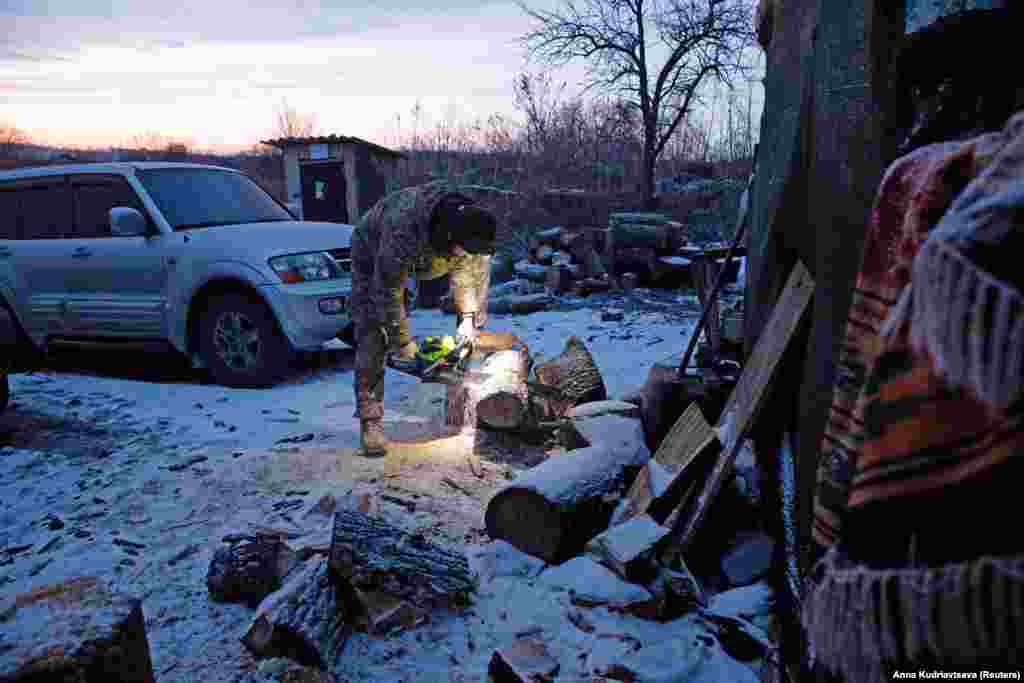A Ukrainian serviceman chops firewood on the front line near the village of Novomykhalivka in the Donetsk region on January 21.