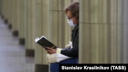 Женщина читает книгу в метро