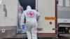 Ukraine. Red Cross workers stand next to a vehicle carrying bodies handed over by Russia.