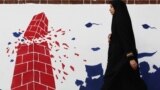 Tehran, Iran - A woman walks past an anti U.S. mural on the former U.S. Embassy's wall in Tehran, Iran January 7, 2020. Nazanin Tabatabaee/WANA (West Asia News Agency) via REUTERS