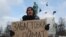 RUSSIA -- Climate activist Arshak Makichyan holds a cardboard reading "Strike for Climate" during a single-person demonstration in central Moscow, February 7, 2020