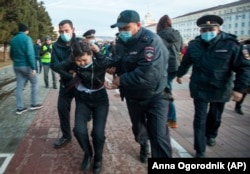 Police officers detain a woman during a protest in support of jailed opposition leader Aleksei Navalny in Ulan-Ude, the regional capital of Buryatia, a region near the Russia-Mongolia border, on April 21, 2021.