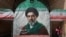 FILE PHOTO: A woman walks next to a banner with a picture of Iran's new Supreme Leader Mojtaba Khamenei in Tehran