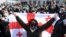 GEORGIA -- A Georgian opposition supporter holds a national flag during a rally following the arrest of the leader of the United National Movement (UNM) in Tbilisi, February 23, 2021