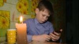 Russia -- boys have to do their school homework in the hall because of electricity outage