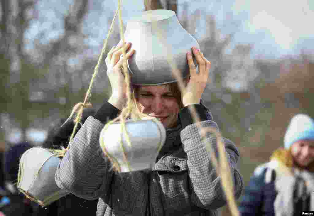 Мужчина принимает участие в конкурсе с горшочками на Масленицу. Озерцо, Беларусь