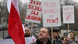 Протесты в Варшаве 19 декабря 2025 года: люди держат плакаты с надписями: "Никаких социальных льгот для украинцев", "Украинская молодежь на фронт!" и "Мы помним Волынь" (массовые убийства поляков украинскими националистами в 1940-х годах) 