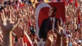 Turkey -- Demonstrators rise their hands and hold a potrait picture of Mustafa Kemal Ataturk, founder of modern Turkey, as they gather at Taksim Square in Istanbul on July 24, 2016. Many thousands of flag-waving Turks massed on July 24, 2016, for the firs