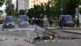 FRANCE -- Gendarmes stand near their vehicles as burning trash in the street in the Gresilles area of Dijon, eastern France, on June 15, 2020, as new tensions flared in the city after it was rocked by a weekend of unrest blamed on Chechens seeking vengean
