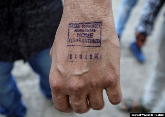 Мужчина показывает штамп с датой прибытия из-за границы, поставленный ему в аэропорту Мумбаи, Индия. 21 марта 2020 года. Фото: Reuters