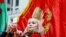 Женщина делает селфи на фоне красного флага в Минске. 7 ноября