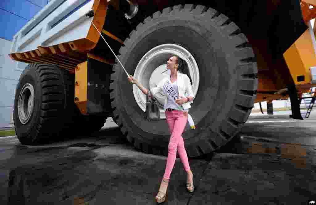 Участница конкурса &quot;Миссис Вселенная-2015&quot; фотографируется на фоне гигантского карьерного самосвала &quot;БелАЗ&quot; в Жодино под Минском (Белоруссия), где производятся эти машины. &nbsp;