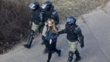 BELARUS -- A woman is led away by Belarusian law enforcement officersat a planned rally after protesters were prevented from doing so by police, who cordoned off several streets, a main square and park in Minsk, March 27, 2021