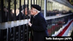 On the 29th anniversary of Black January, a man kisses a tomb stone at the Alley of Martyrs, a cemetery and memorial dedicated to those killed by Soviet troops on January 20, 1990 in Baku.