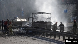 Украинские пожарные и сотрудники экстренных служб тушат сожженную технику на месте столкновения с российскими военными. Киев, 26 февраля 2022 года. Фото: Reuters