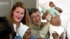 Mozambique -- Bill and Melinda Gates, co-founders of the Bill and Melinda Gates Foundation, plays with young patients on a malaria vaccine trial at the Manhica Health Research Centre in Manhica, 80 km north of Maputo, September 23, 2003