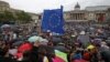 U.K. -- A demonstrator waves a European flag as people shelter under umbrellas at an anti-Brexit protest on Trafalgar Square in central London, June 28, 2016